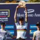 Finn Treudler celebra en la final de temporada del Cube Factory Racing 2025 en Mont-Sainte-Anne, sosteniendo el trofeo en sus manos, flanqueado por los ciclistas que ocuparon el segundo y tercer lugar en el podio.