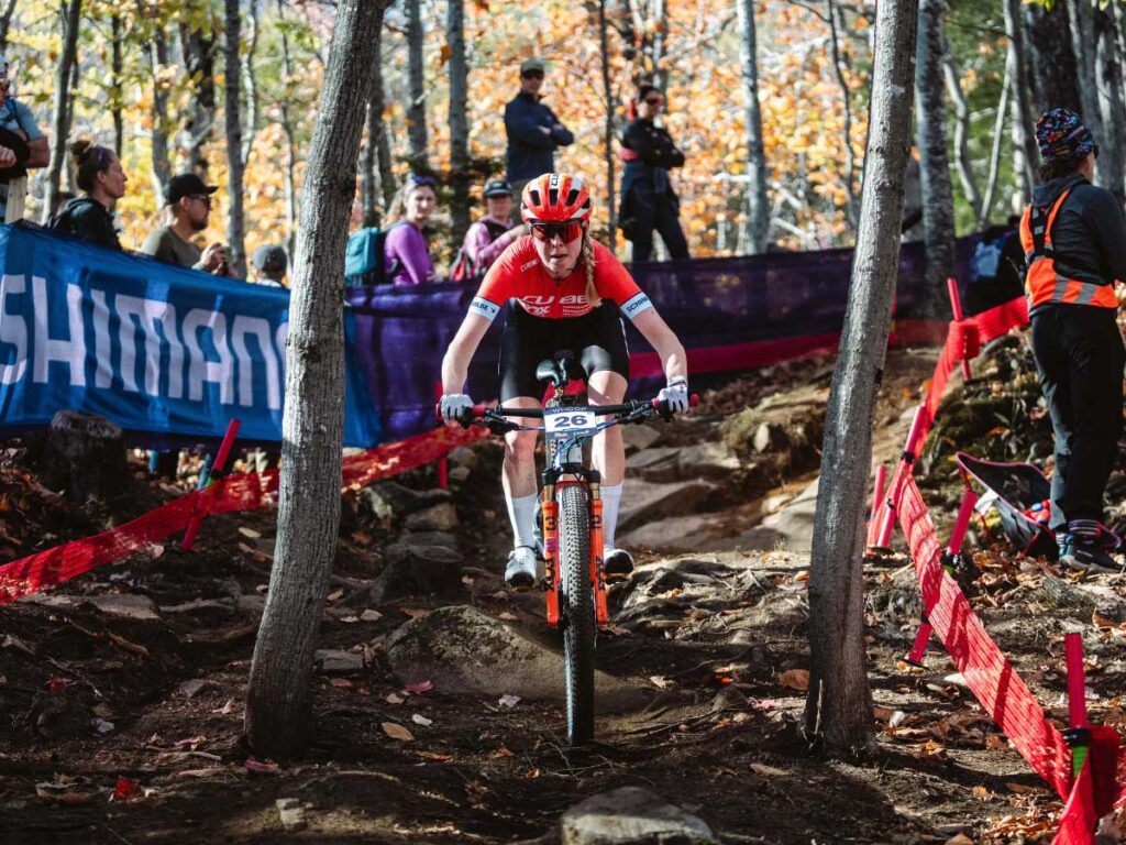 Kira B&ouml;hm avanza con total concentraci&oacute;n por la secci&oacute;n forestal t&eacute;cnica durante la final de temporada del Cube Factory Racing 2025 en Mont-Sainte-Anne, sobre su bicicleta de monta&ntilde;a Cube.